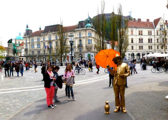 Presernov trgu, with a golden statue and an orange umbrella.